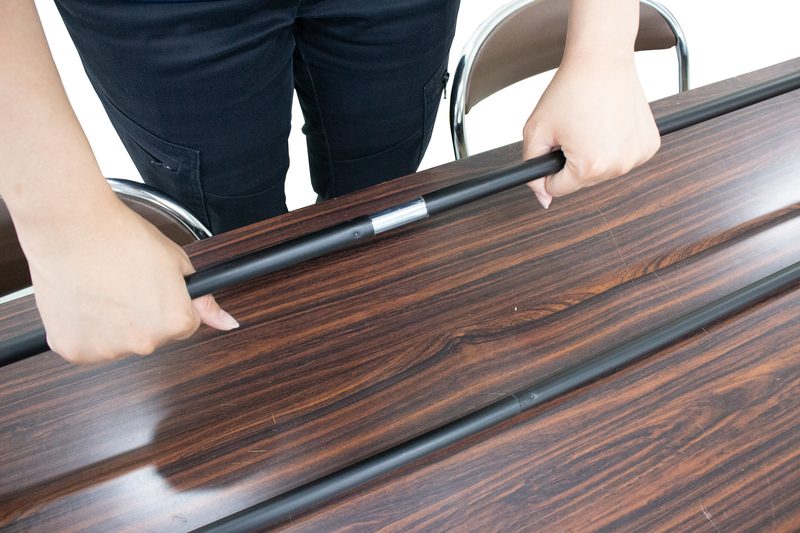 継ぎ足し式のパイプのつなぎ目を両手で持っているところ